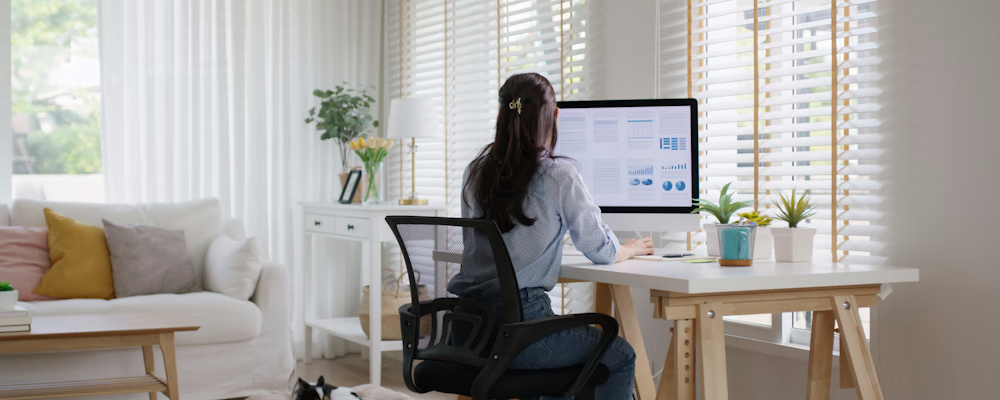 Woman using computer at a living room desk