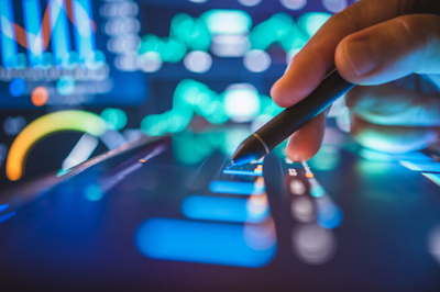 A hand touches a stylus on a touchscreen panel