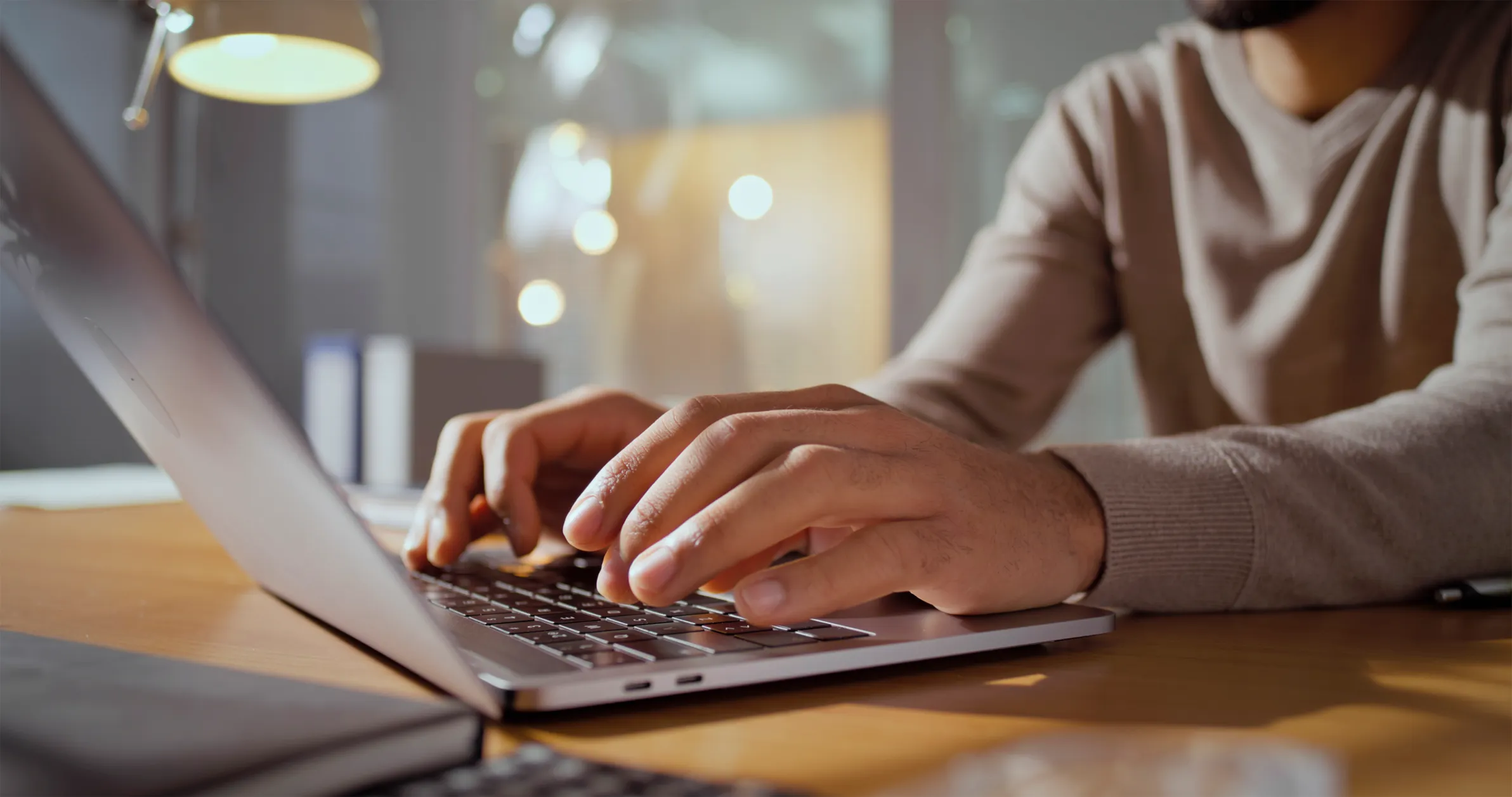 Hands typing on a laptop as a routine email is opened