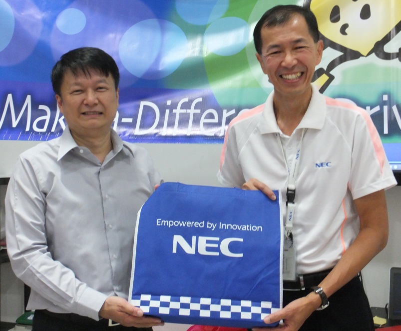 Mr Lim Kok Quee, Managing Director of NEC Asia Pacific (right) presenting a corporate gift to  Executive Director of FFTH Mr Anson Quek (left)